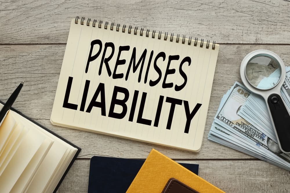 Desk with legal documents, cash, and magnifying glass for premises liability case.